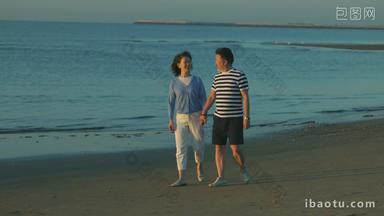 老年夫妇手牵手在海边散步